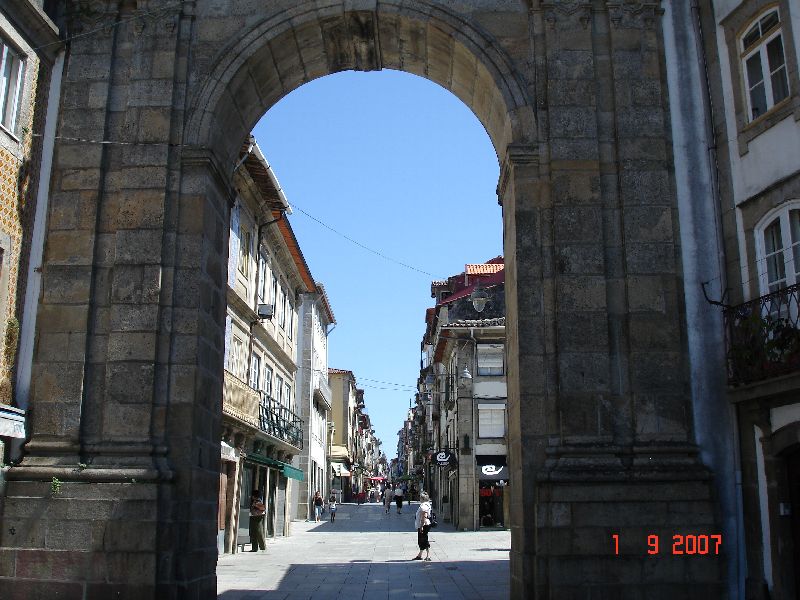 Une porte médiévale donnant accès à une rue piétonne de Braga, Portugal.