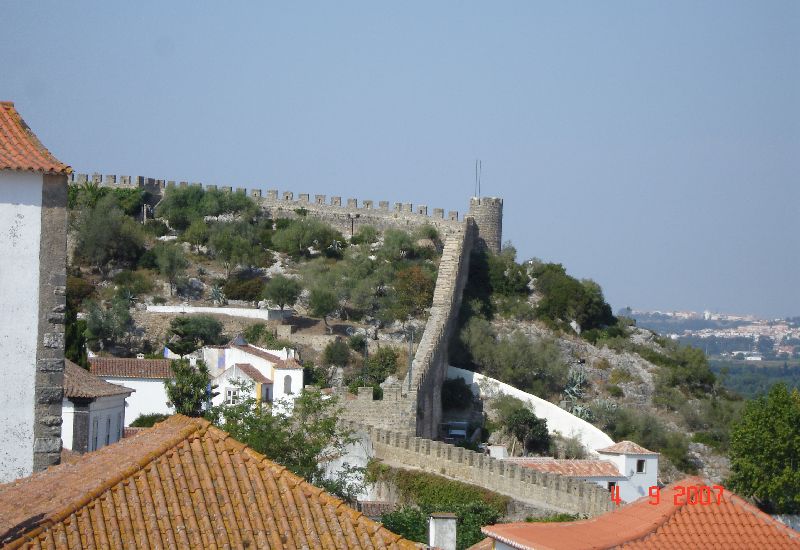 Des remparts crénelés et une tour de guet, Óbidos, Portugal.