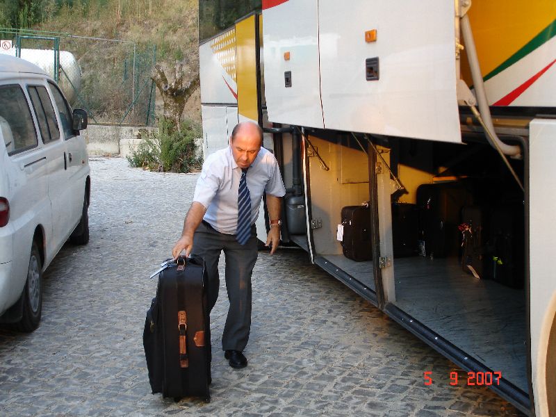 Travailleur infatigable, notre chauffeur José, place nos bagages dans la soute de l'autocar. Ourem, Portugal.