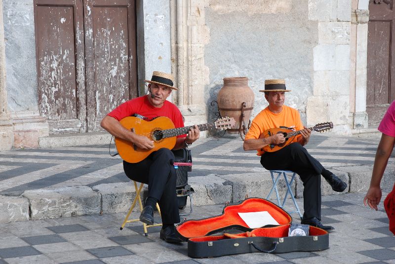 Des musiciens distraient la foule sur une place publique à Taormina, Italie.